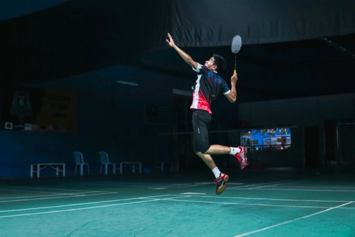 homme smash au badminton