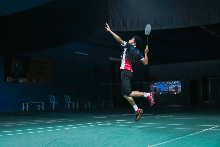 un joueur smash en sautant au badminton