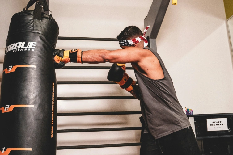 un homme qui frappe un sac de boxe dans sa maison